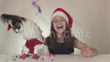 穿着圣诞老人服装的美丽少女和狗大陆玩具西班牙狗乳头，尽情享受新年的`。